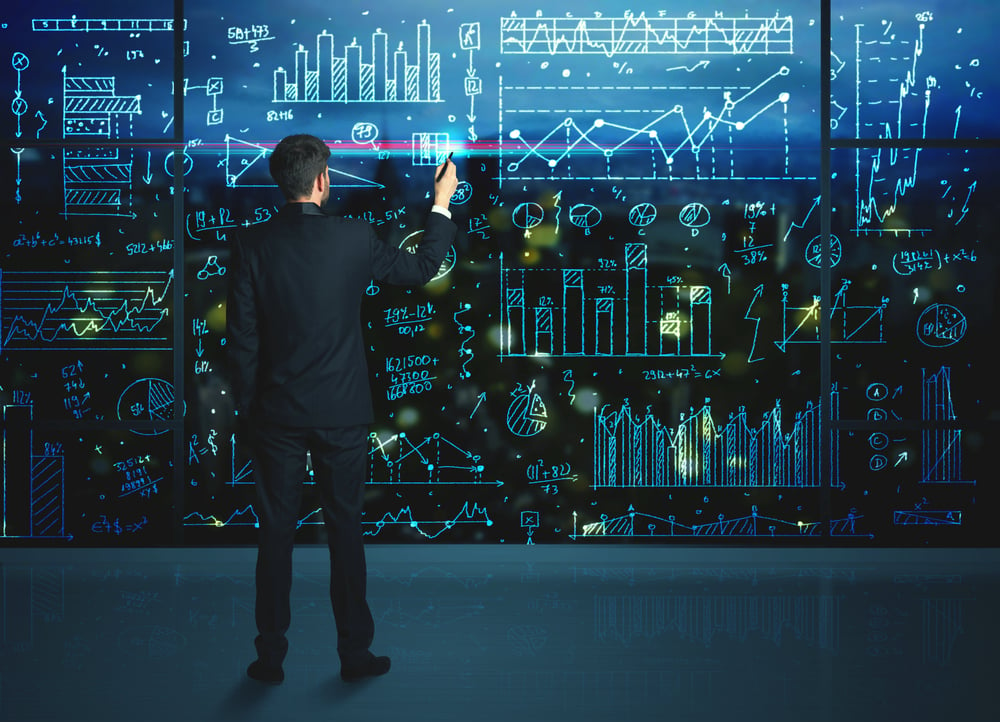 Businessman drawing business statistics on glass wall-1