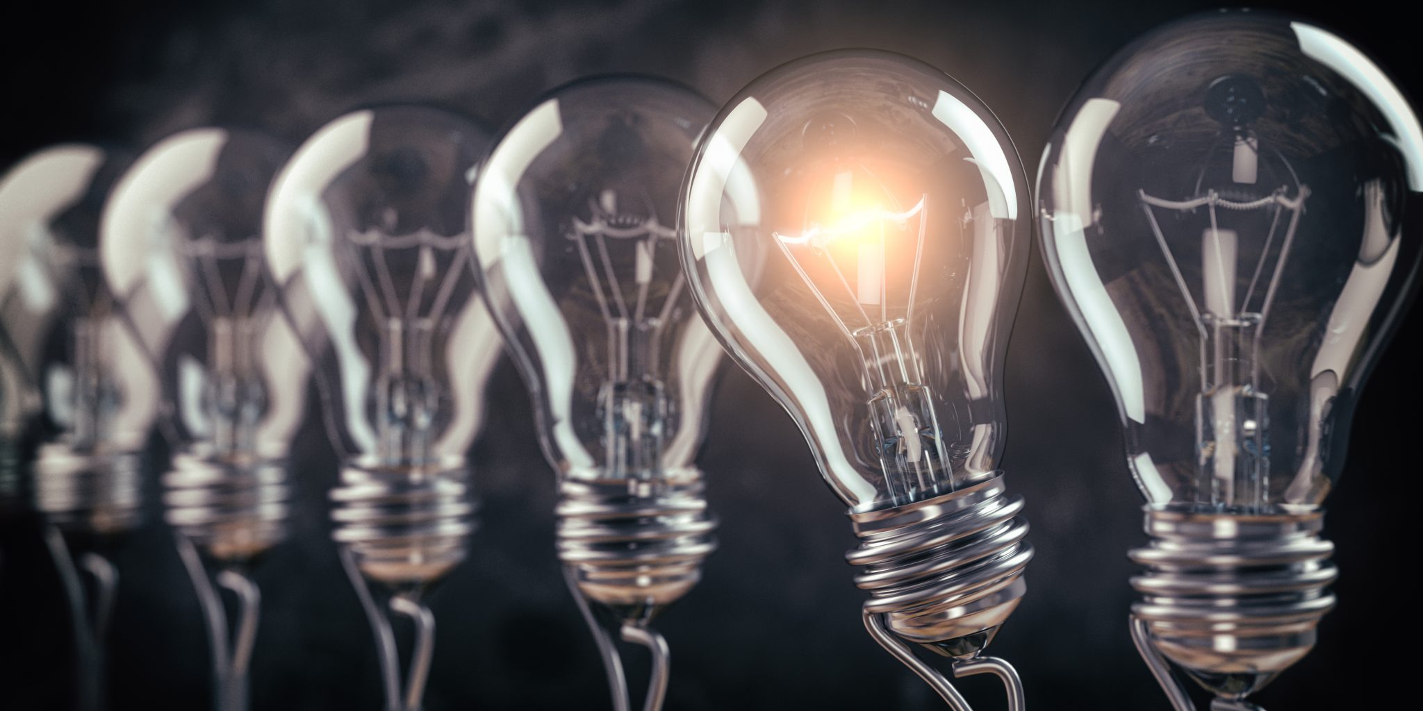 row-of-light-bulb-with-a-one-glowing-idea-and-inno